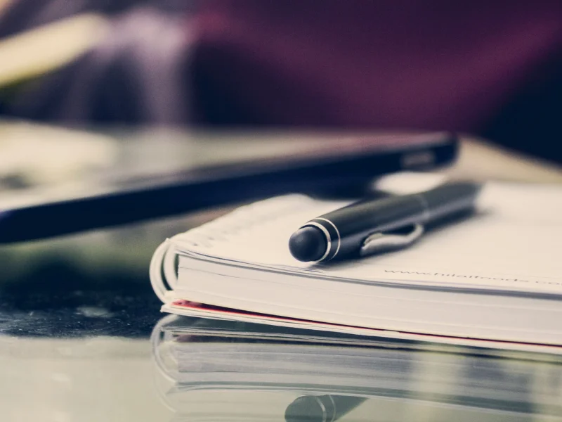 Carnet et stylo posés sur un bureau