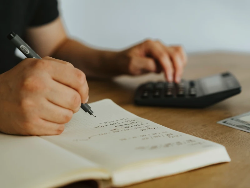 Prise de notes dans un carnet avec une calculatrice